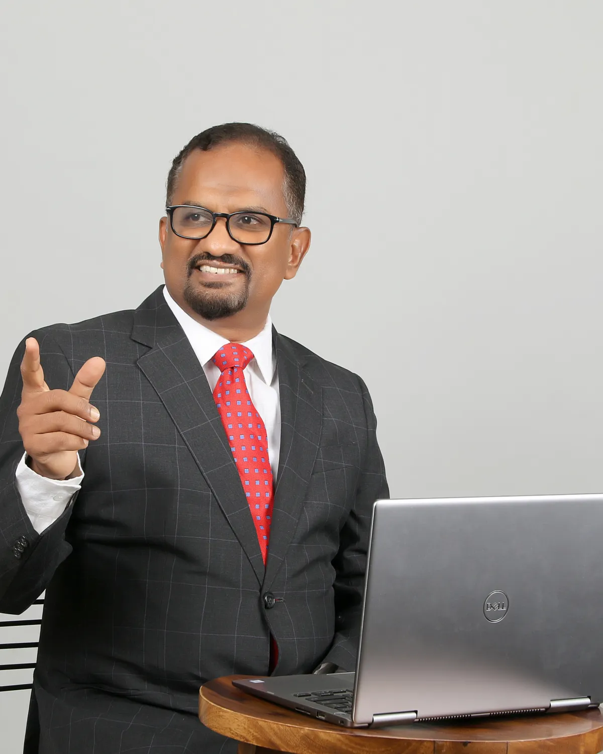 Sabu Thomas speaking, gesturing beside a laptop